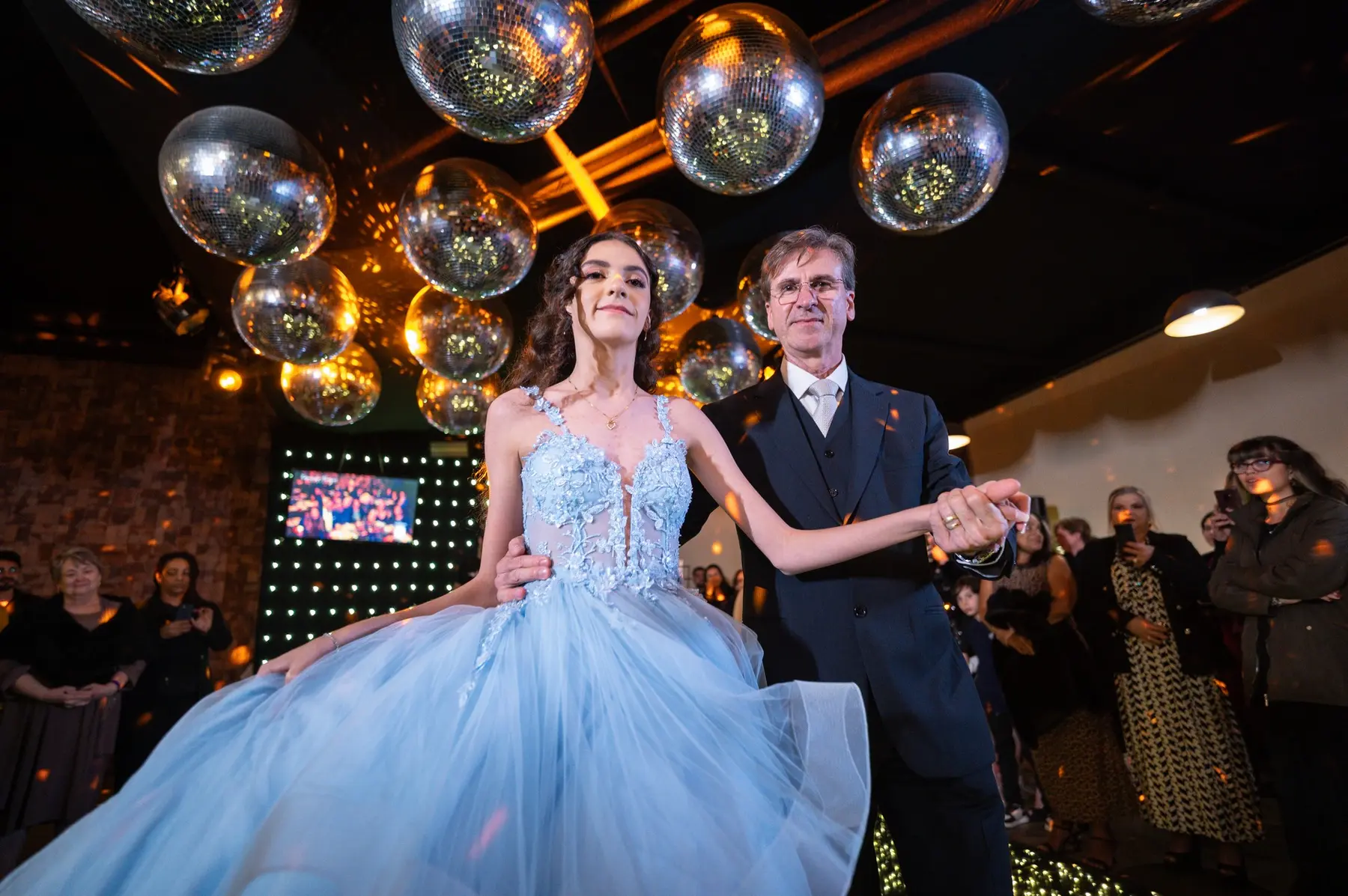 Luiza celebrando com os convidados durante sua festa de 15 anos